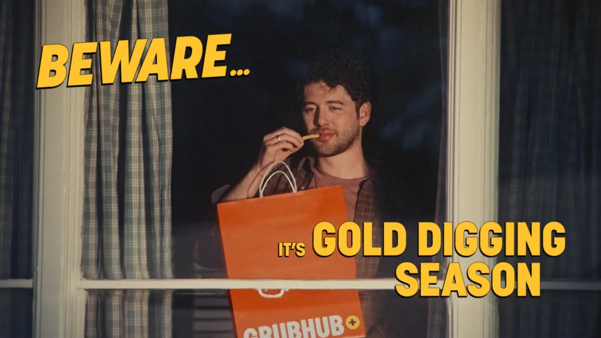 A man looks out his window holding a Grubhub bag in one hand and a single fry in another, with the words, "Beware... It's Gold Digging Season."