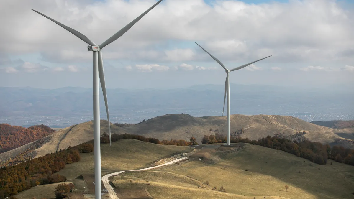 Wind turbines stand on a mountain in Kosovo.