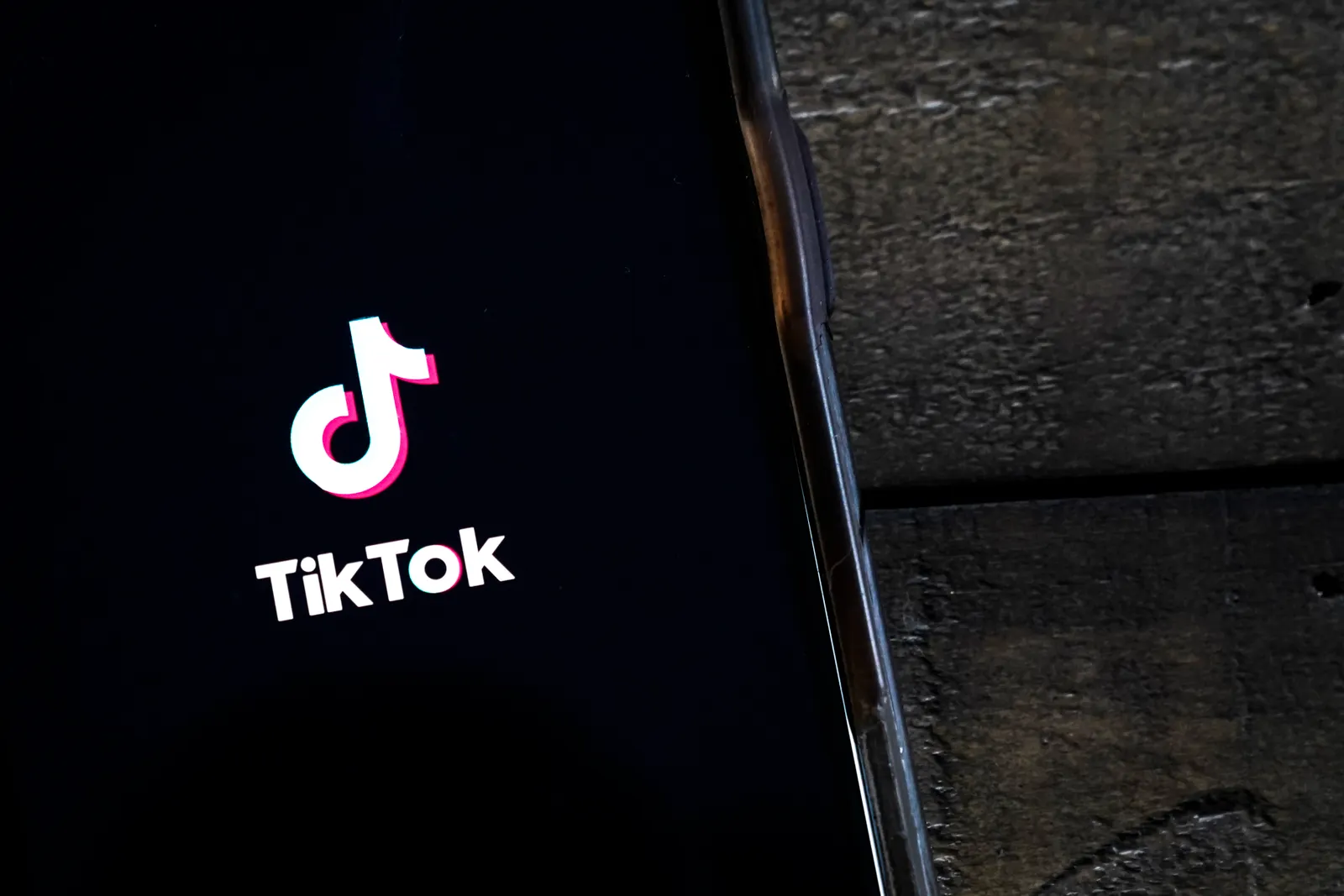 The TikTok app is displayed on an Apple iPhone.