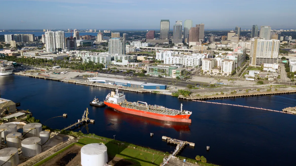 An image of a large ship on a river traveling through a city.