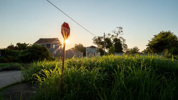 The sun rises behind distant houses in the Lower Ninth Ward in New Orleans, Louisiana.