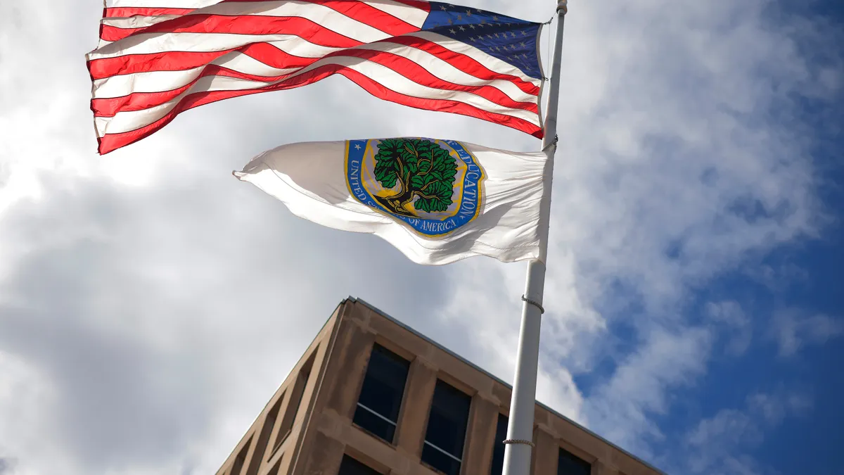 he U.S. flag and Department of Education flags whip in the wind outside the department's headquarters