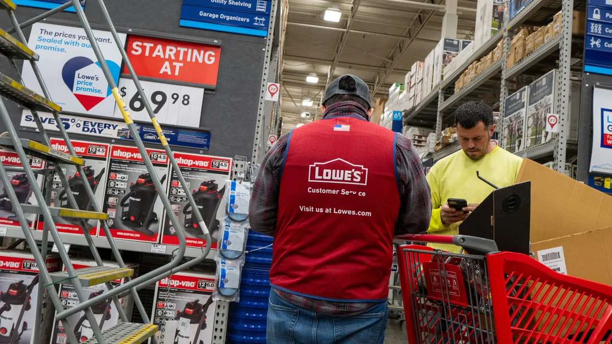 A Lowe's associate helps a customer in a store