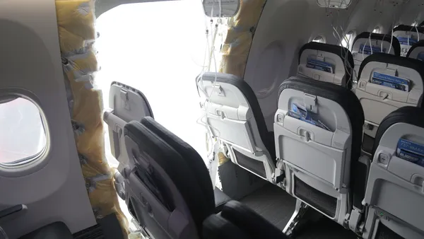 Rows of empty airline seats and an opening inside a Boeing 737-9 Max.