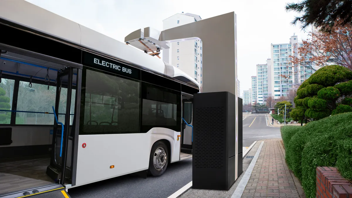 An electric bus charging on a public street.