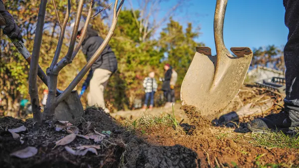 Spade on ground and people on the background