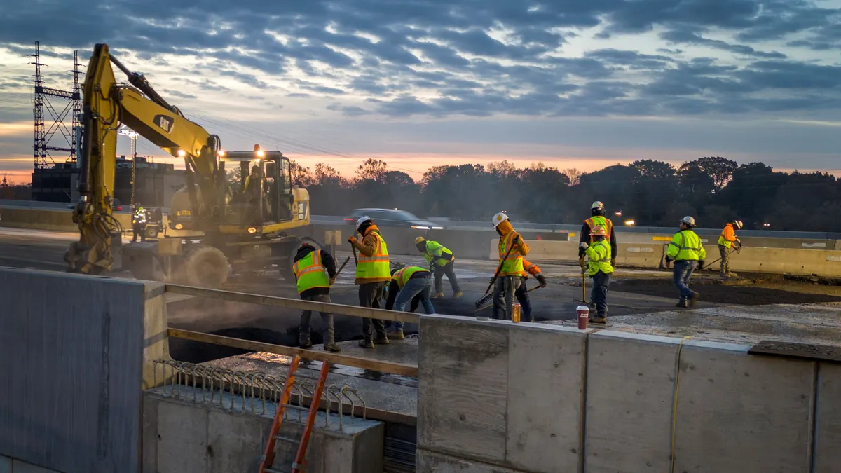 A group of construction workers on a roadway.