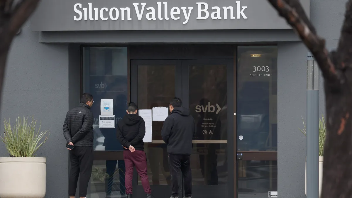 Employees stand outside of the shuttered Silicon Valley Bank (SVB) headquarters on March 10, 2023 in Santa Clara, California.