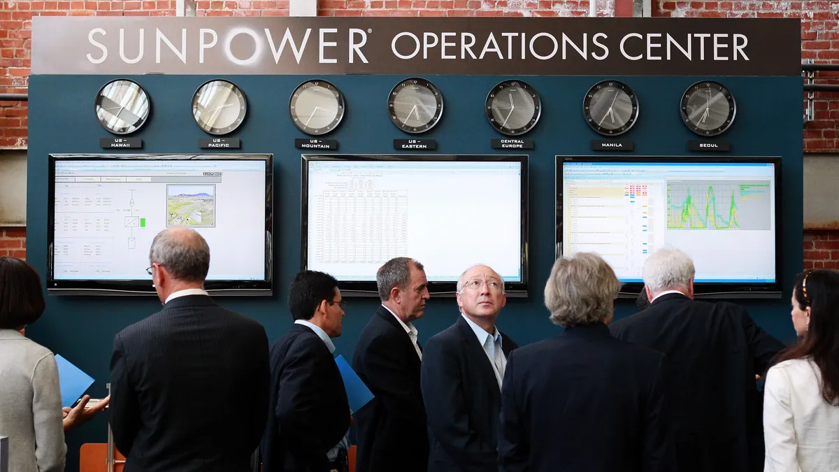 U.S. Secretary of the Interior Ken Salazar (C) looks at the Sunpower operations center during a tour of Sunpower Corporation's research and development facility October 14, 2010.