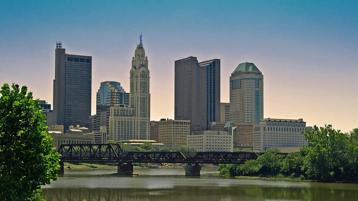 The skyline of Columbus, Ohio, seen behind a river.