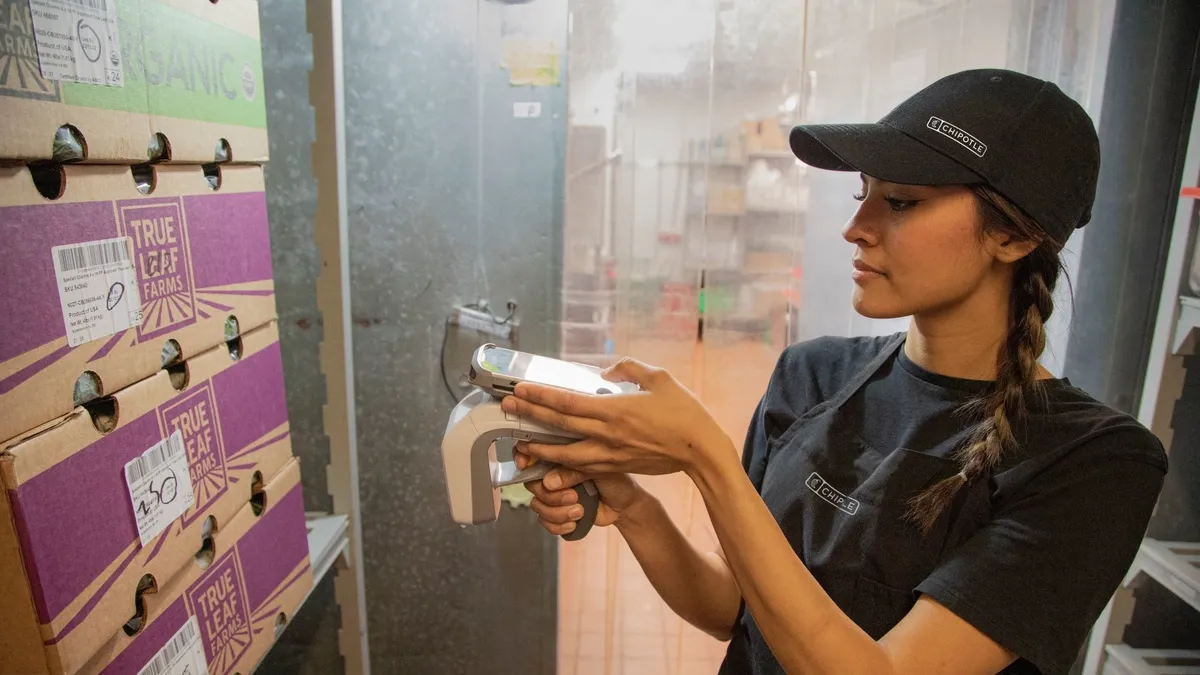 A Chipotle worker scans an RFID tag on a box as part of a growing traceability initiative