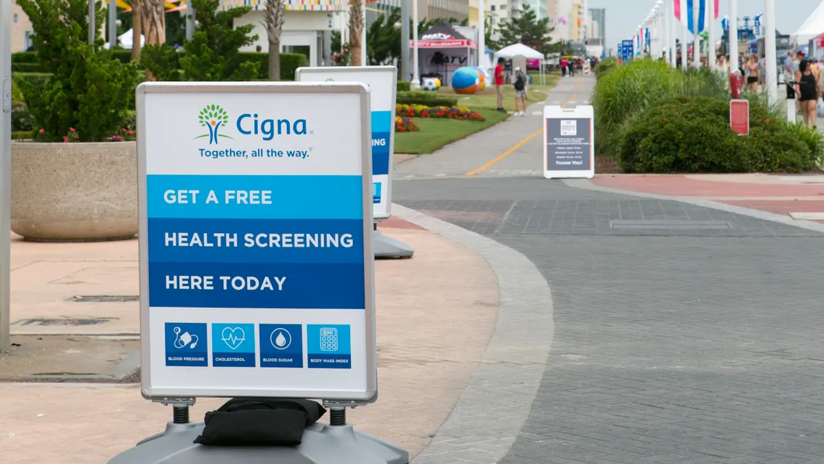 A sign advertises Cigna's free health screenings as the Cigna HIT tour takes to the beach on May 31, 2019 in Virginia Beach, Virginia.