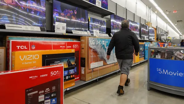 Vizio TVs in a Walmart as a person walks by
