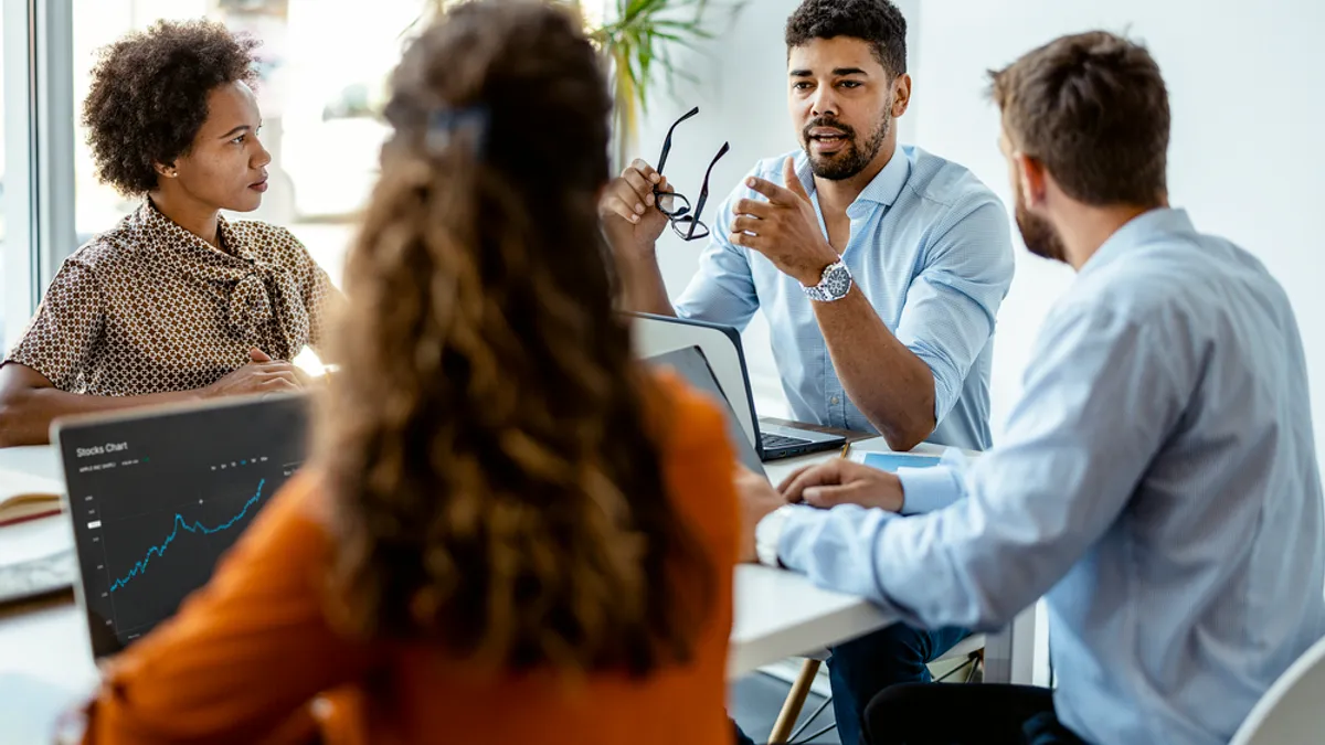 Professionals have a meeting in front of a computer.