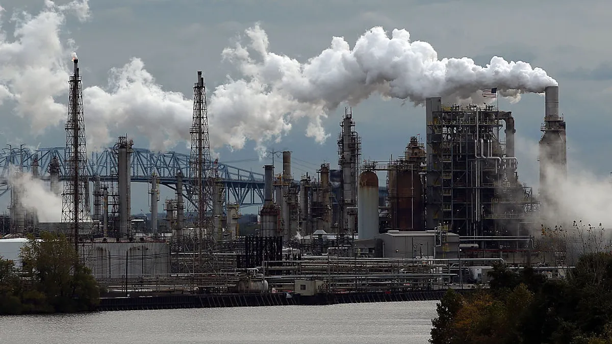 An image of the largest crude oil by rail unloading terminal in the United States with smoke billowing out of multiple smokestacks.