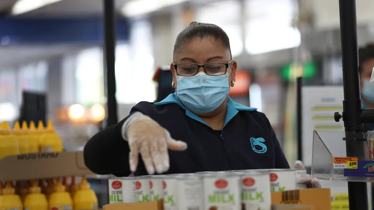 A grocery store employee checks food items.