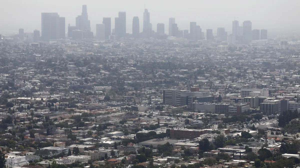 Air pollution hangs over city skyline and urban sprawl.