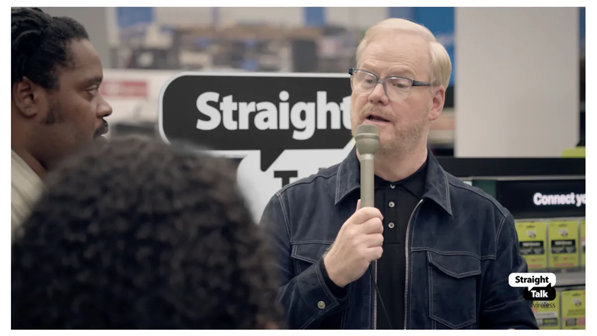 Jim Gaffigan holds a microphone inside a Walmart.