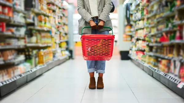 A woman stands in a supermarket aisle.