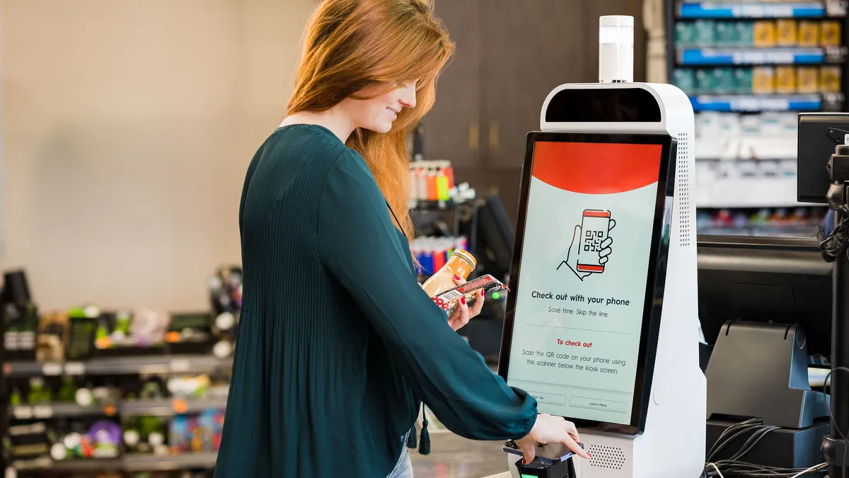 A photo of a person using a Grabango machine to check out.