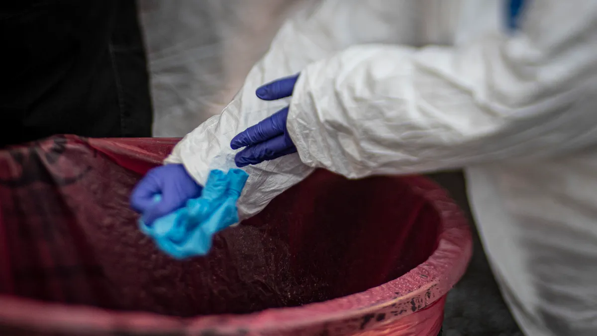 A medical technician changes out gloves between patients at a COVID-19 Community-Based Testing Site at the PNC Bank Arts Center in Holmdel, N.J., March 23, 2020. The testing site, established in partn