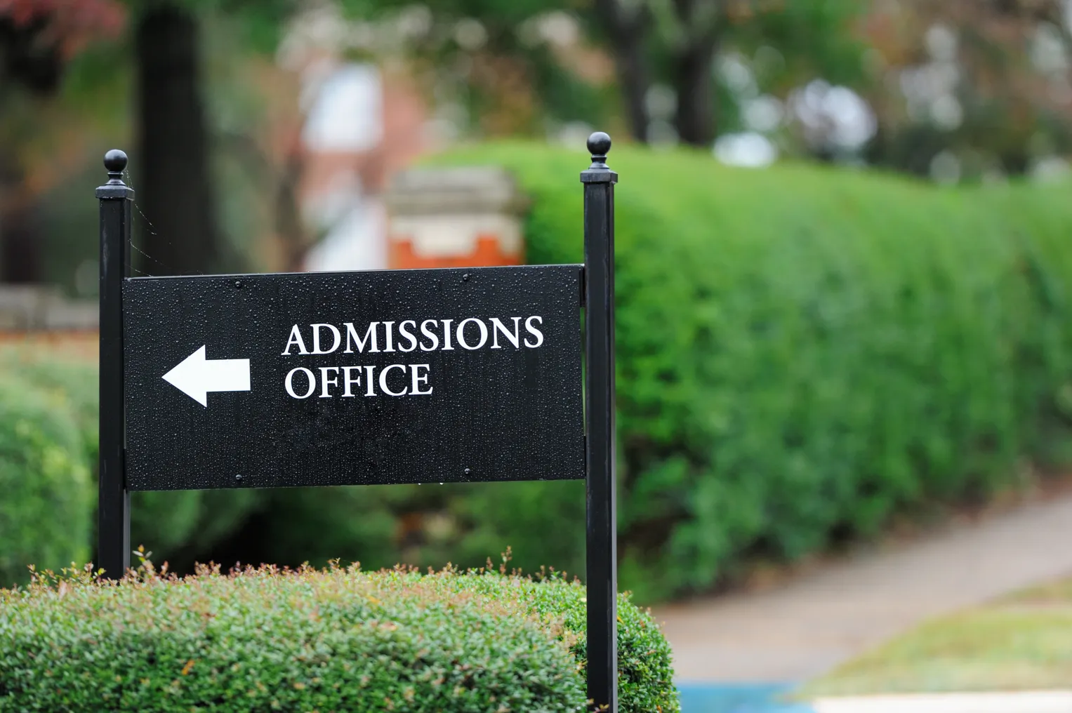 A sign advertises a college admissions office.