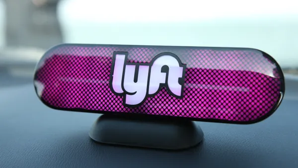 A photo of a Lyft logo on a car's dashboard.