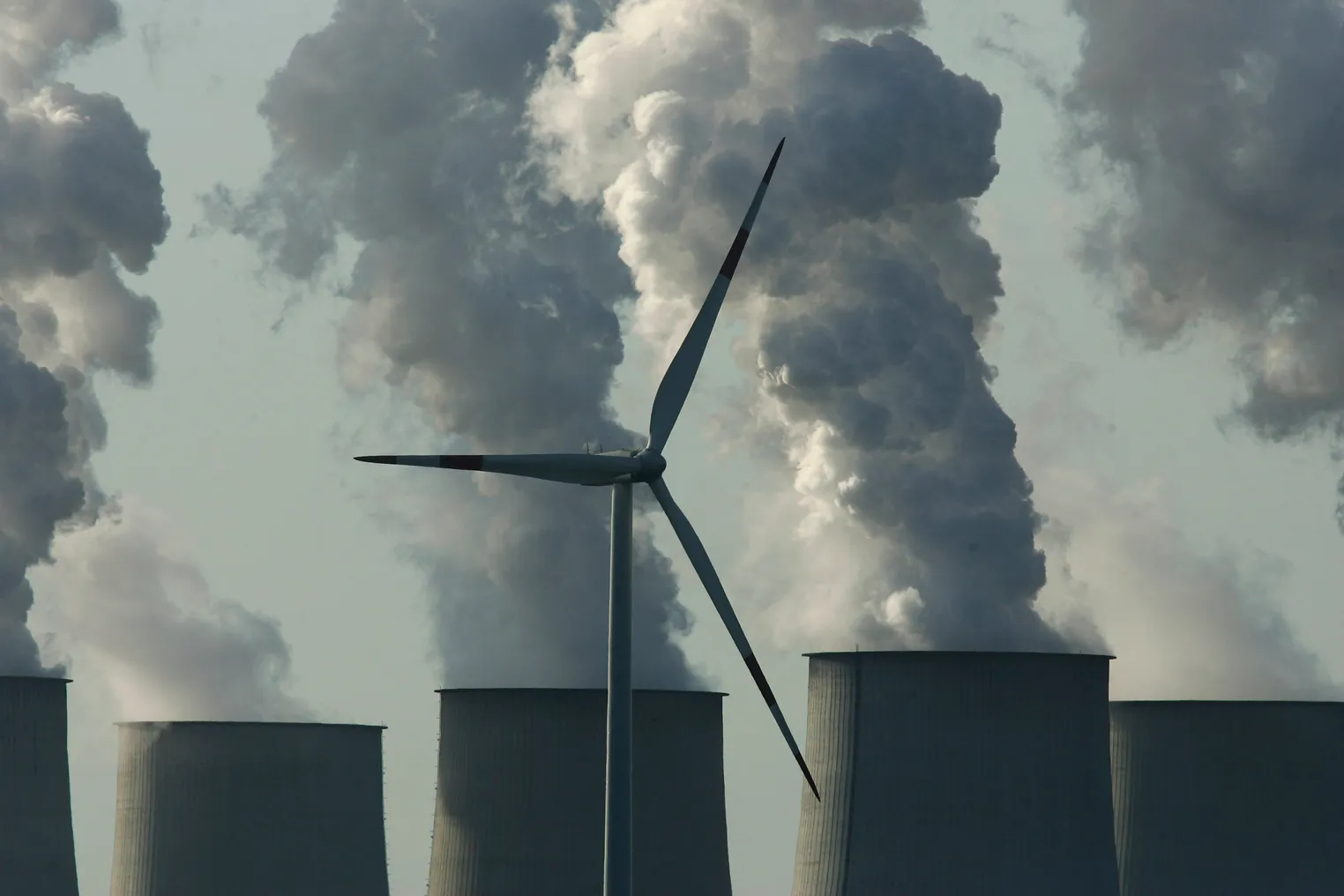 A lone wind turbine spins as exhaust plumes from cooling towers at the Jaenschwalde lignite coal-fired power station, which is owned by Vatenfall, April 12, 2007 at Jaenschwalde, Germany.