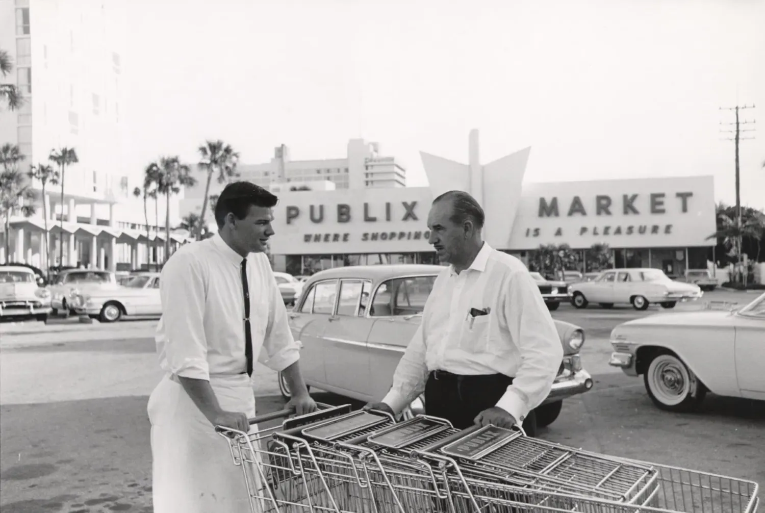 Two people talking with each other outside a grocery store.