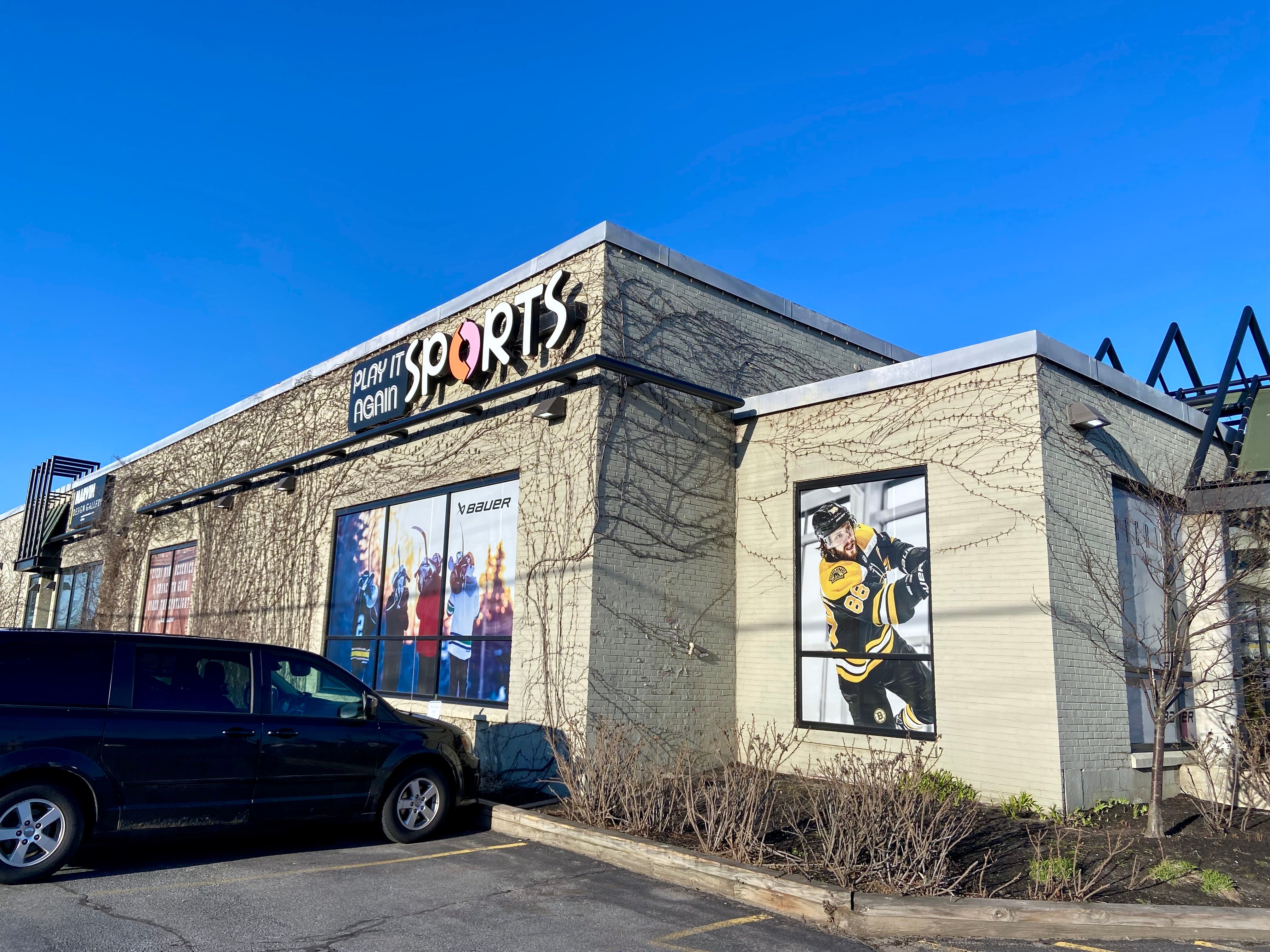 A store seen at an angle, with "Sports" on one corner, and a photo of a hockey player prominent on the right.