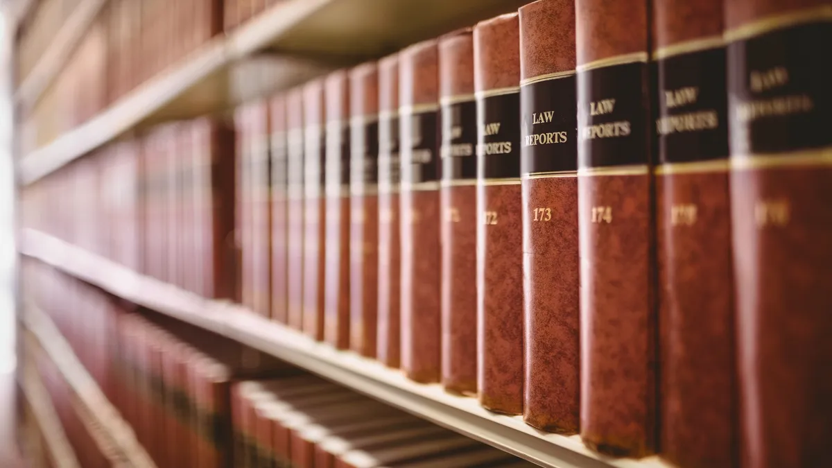 A close up of a long library bookshelf full of law books.