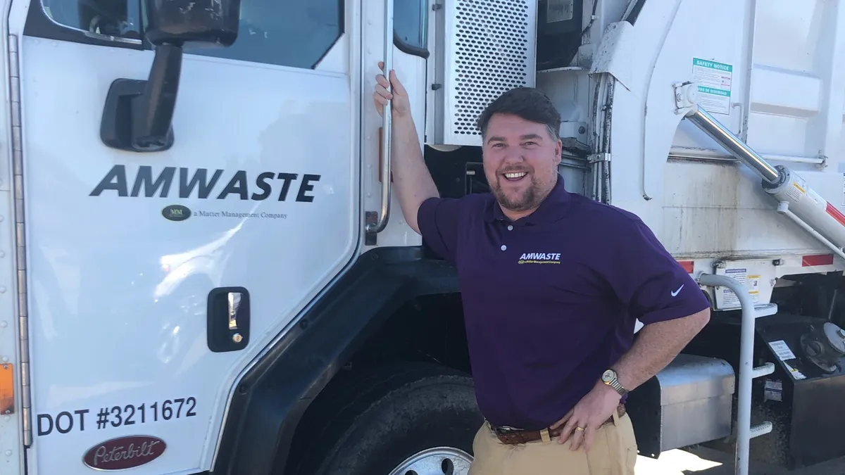 Amwaste CEO Chip Russell stands next to one of his company's collection trucks