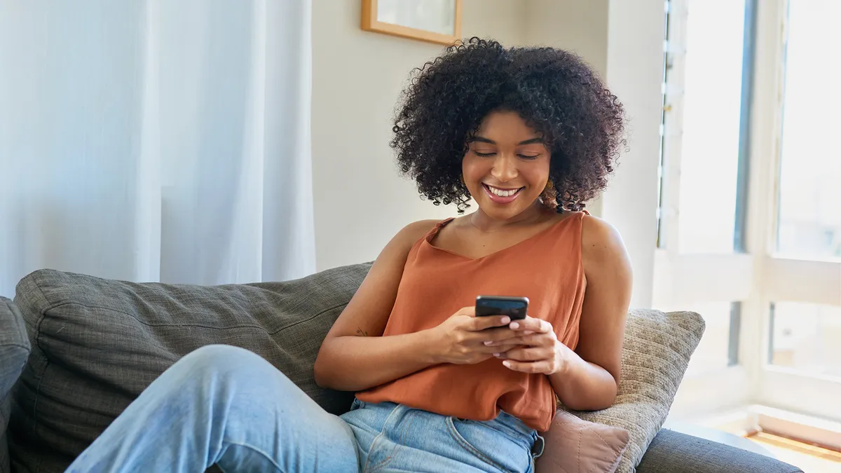 Person lounging on couch, looking at phone