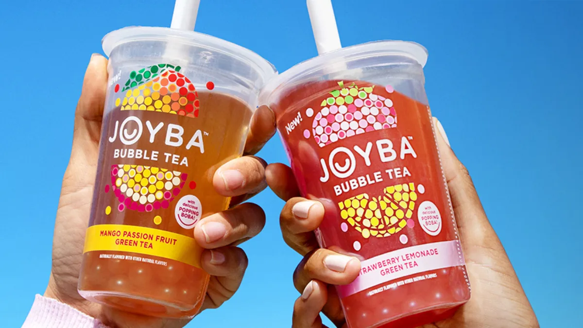 Two hands holding two cups of Joyba bubble tea.