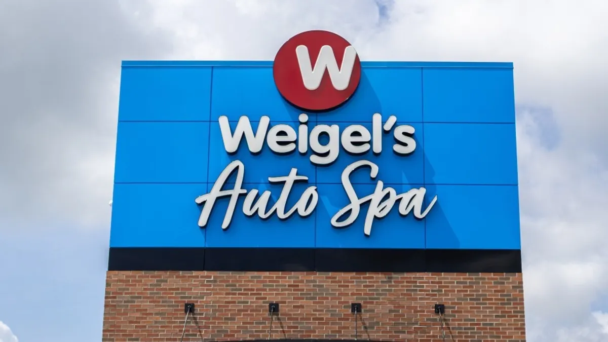 A photo of a sign, in blue and white. The sign says "Weigel's auto spa."