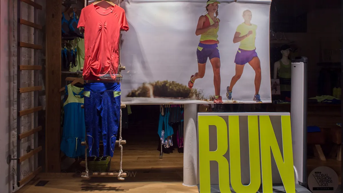 Activewear on display as seen through a storefront window.