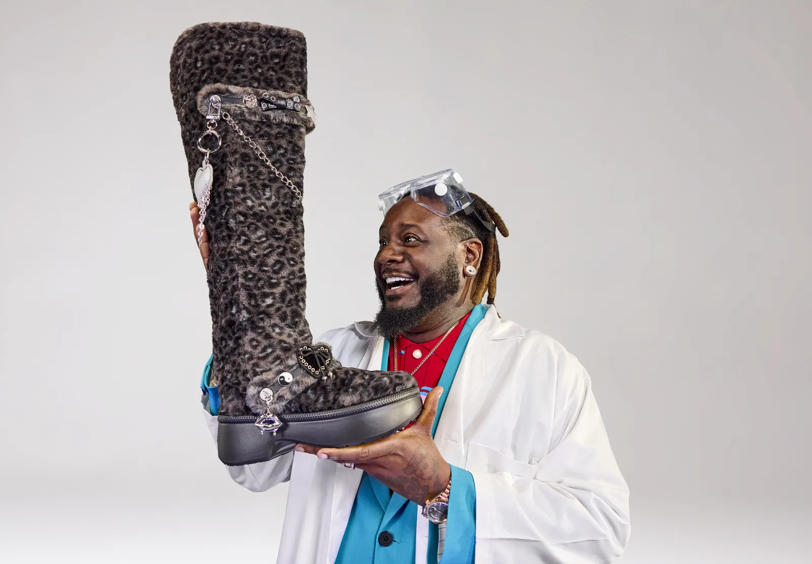 T-Pain holding leopard print fur boots from Crocs