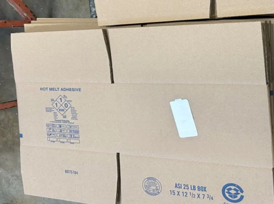 Flattened corrugated boxes with smart labels are stacked.