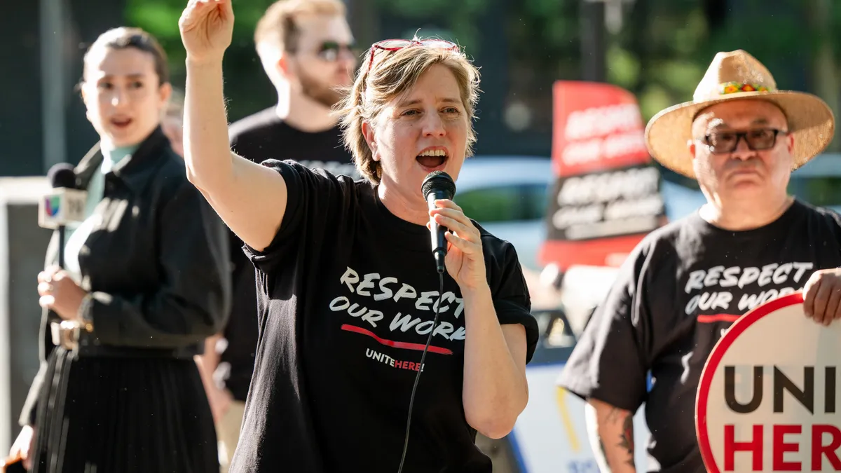 Mills shouts into a megaphone at a demonstration.