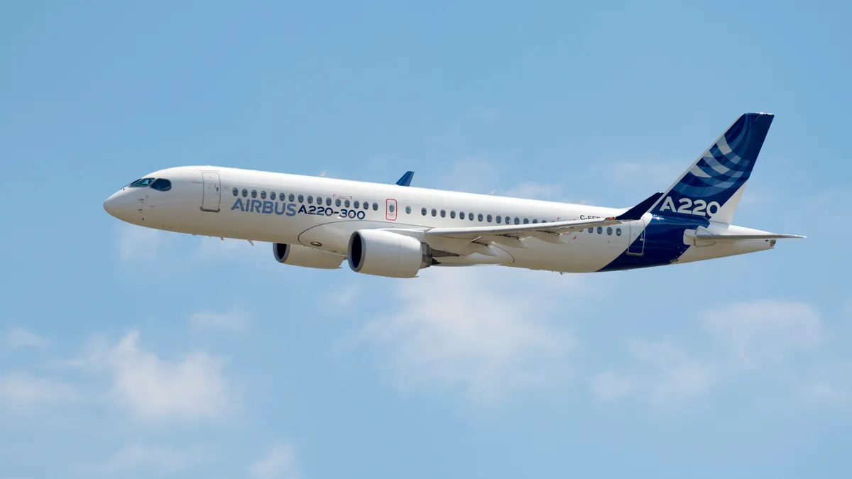 A white and blue plane flying in the air.