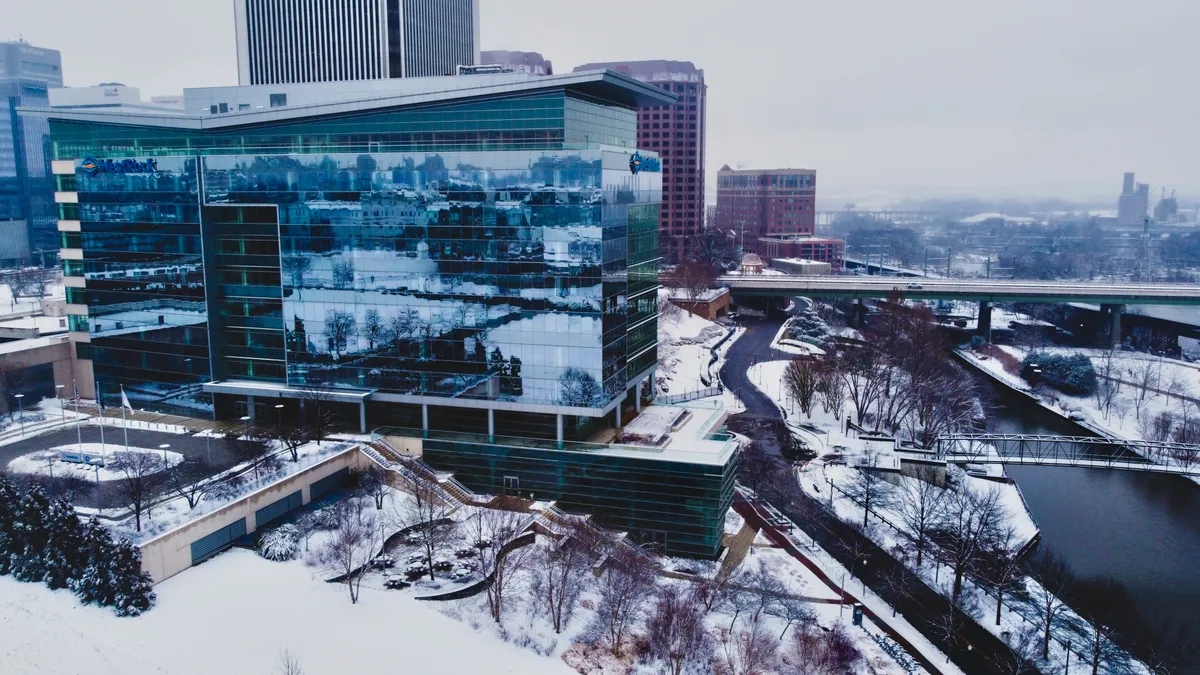 Office building with glass windows alongside a river with snowy environment