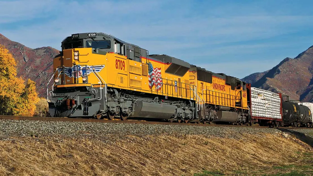 A rail train passing though a railroad track.