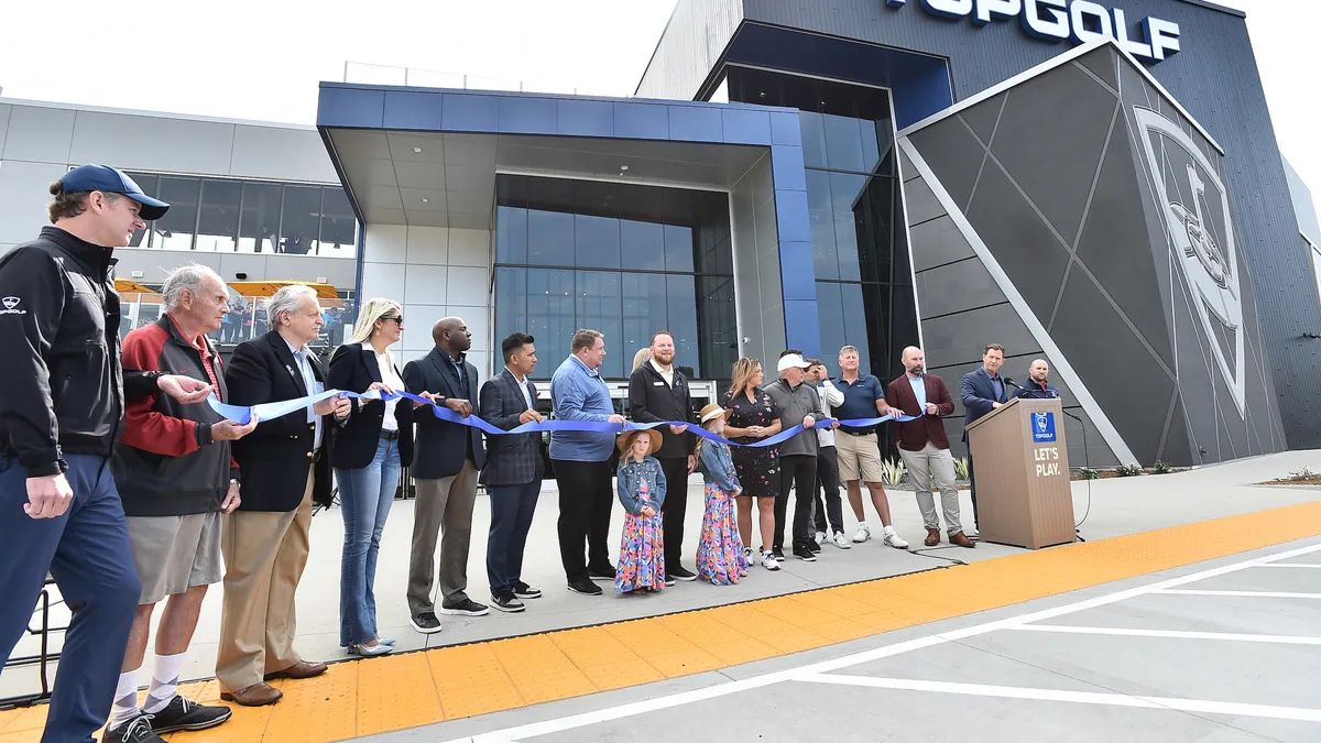 A group of executives and stakeholders all share in the ribbon cutting ceremony for the new Topgolf location in El Segundo, California.