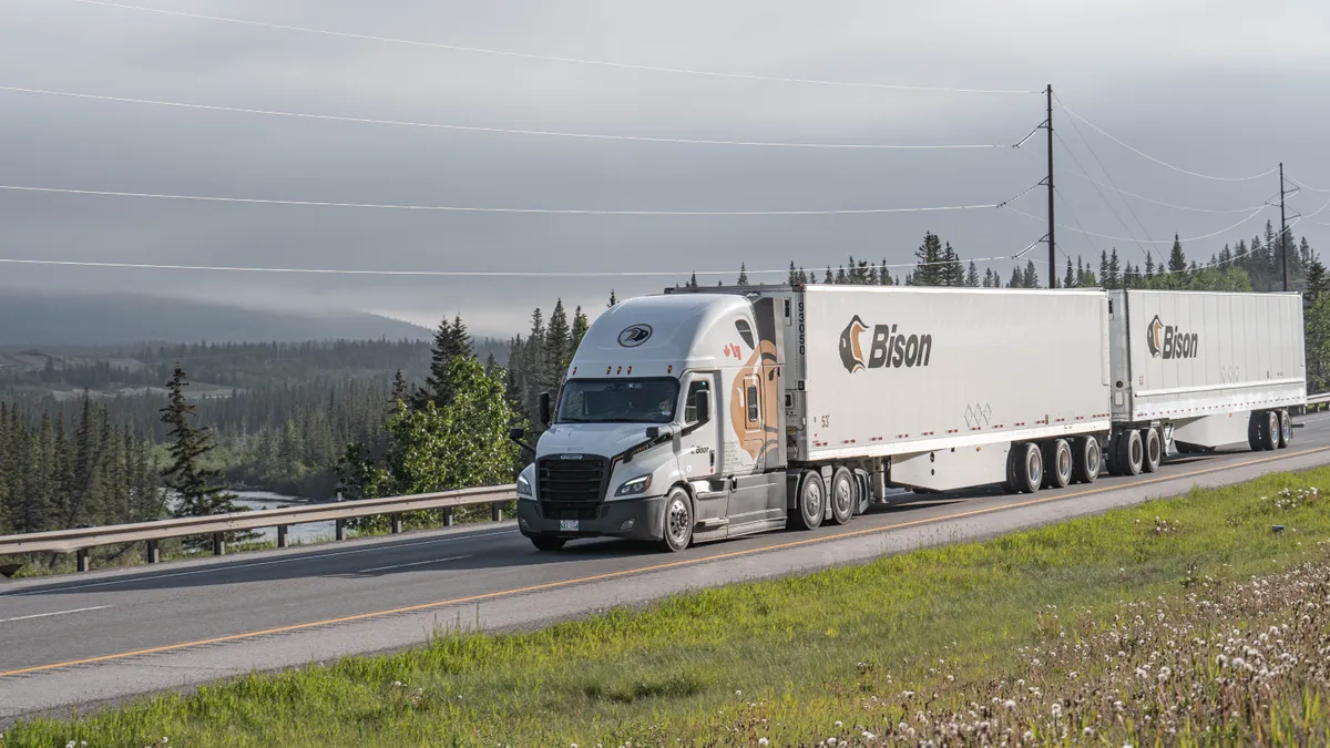 A Bison Transport double trailer with a mountainous scenery in the background.