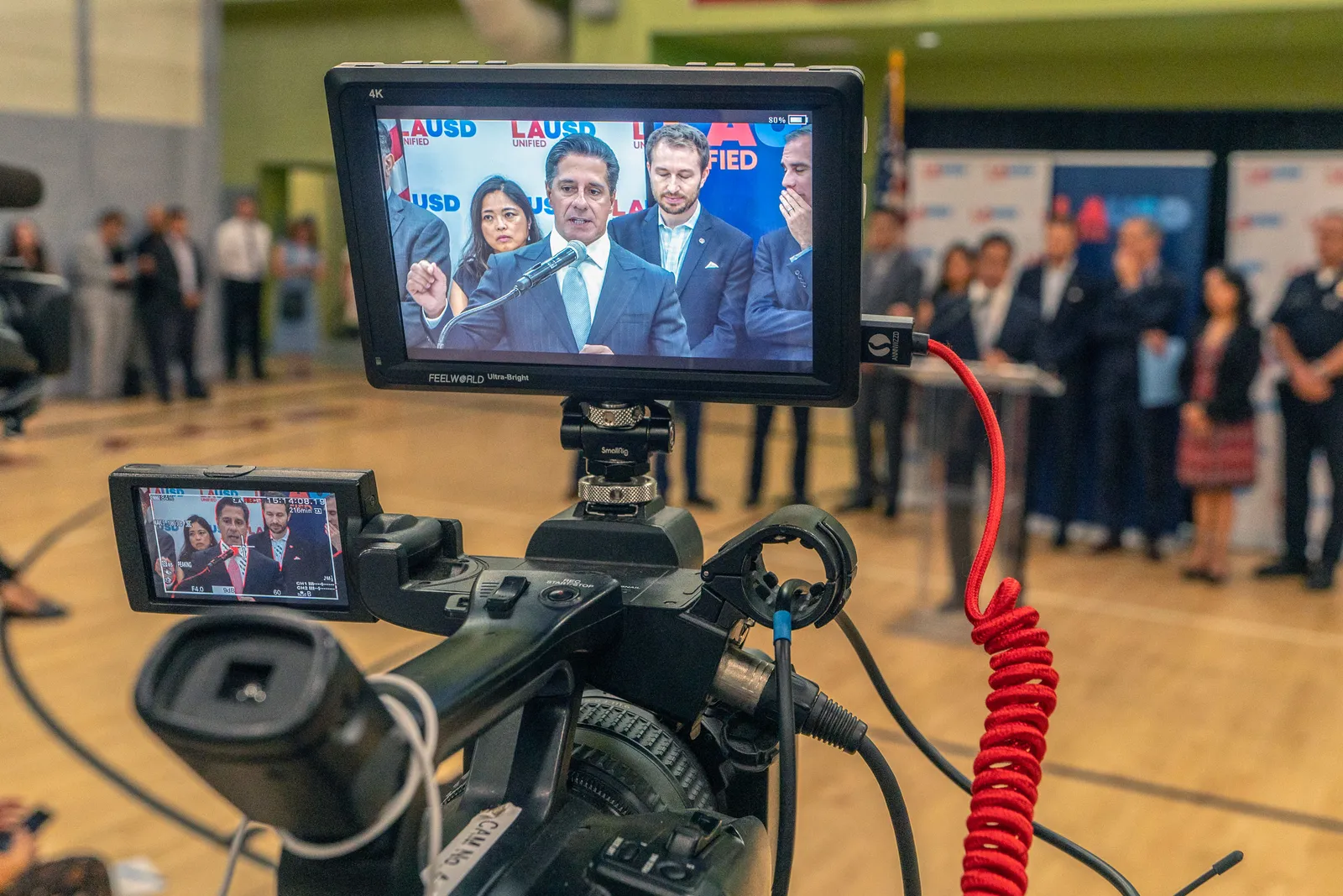 Los Angeles Unified School District Superintendent Alberto Carvalho and staff are shown during a news conference through the display screen on a video camera.