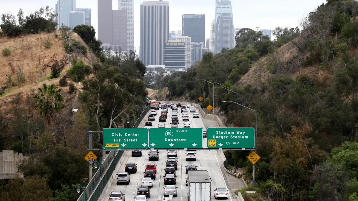 A view showing the skyscrapers of downtown Los Angeles with a freeway full of traffic in the foreground.