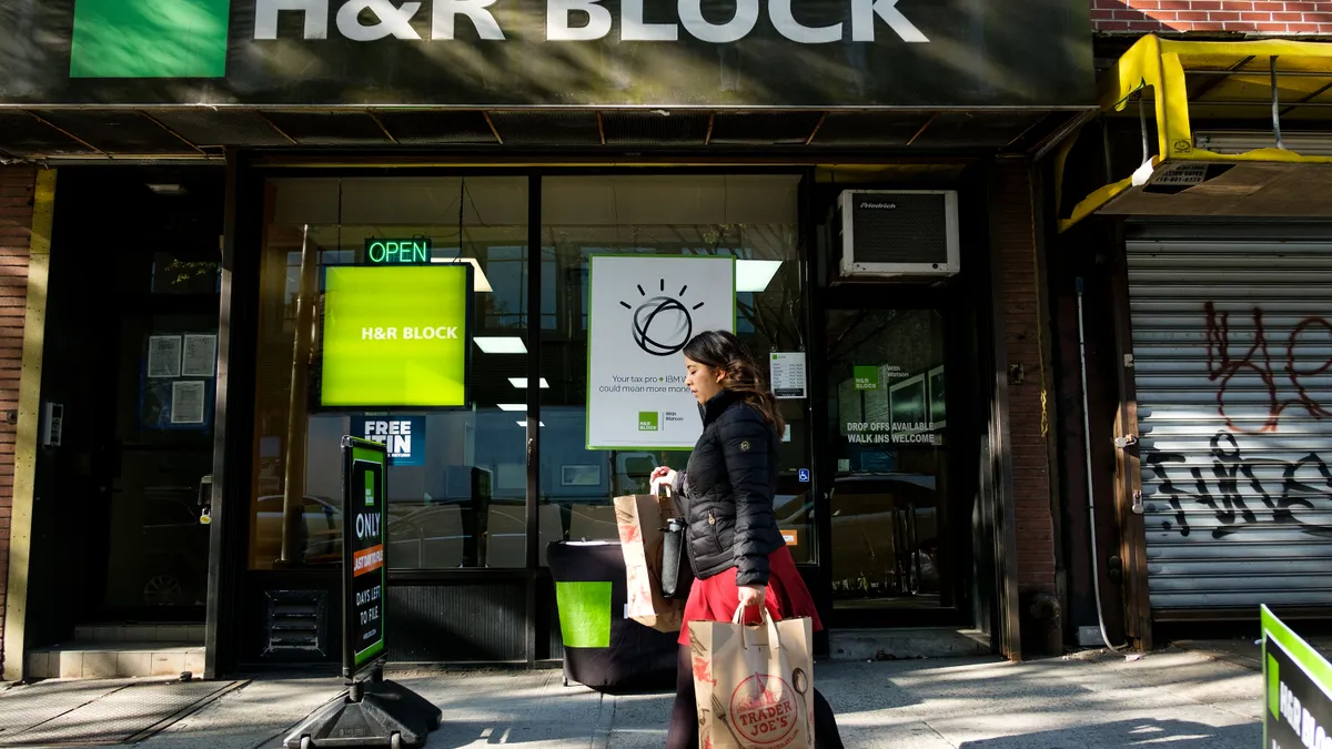 A woman walks past an H&R Block office.