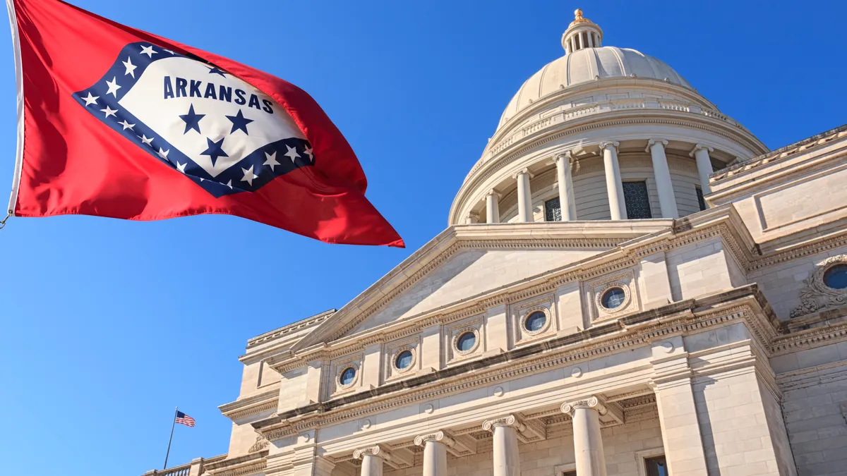 Flag blows outside state capitol building.