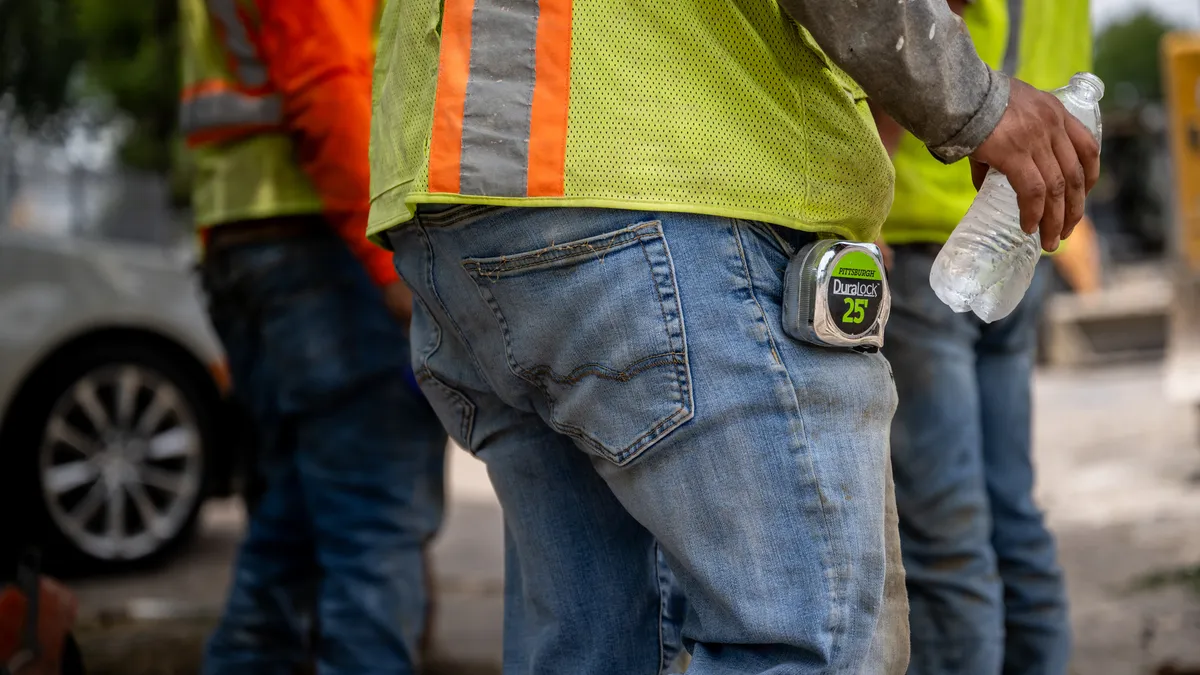 A shot of three construction workers mid sections.