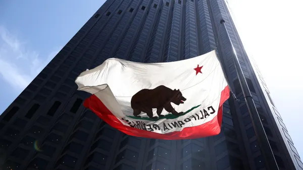 California's flag flies in front of a large commercial building